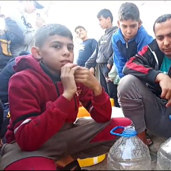 Människor i gaza häller upp vatten i flaskor.