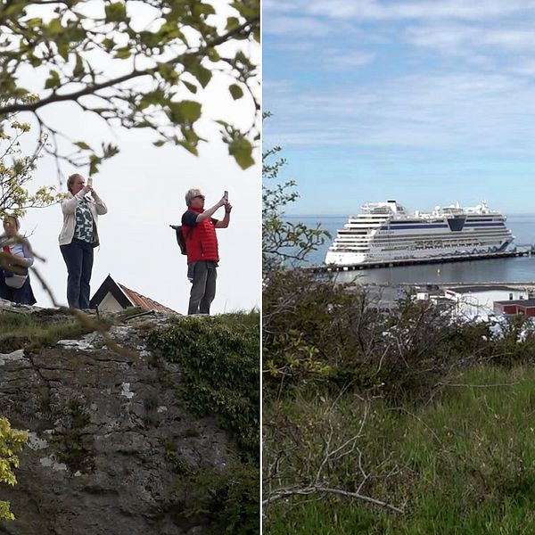 Turister står på en höjd och fotograferar. Ett fartyg syns i hamnen. Visby domkyrka.
