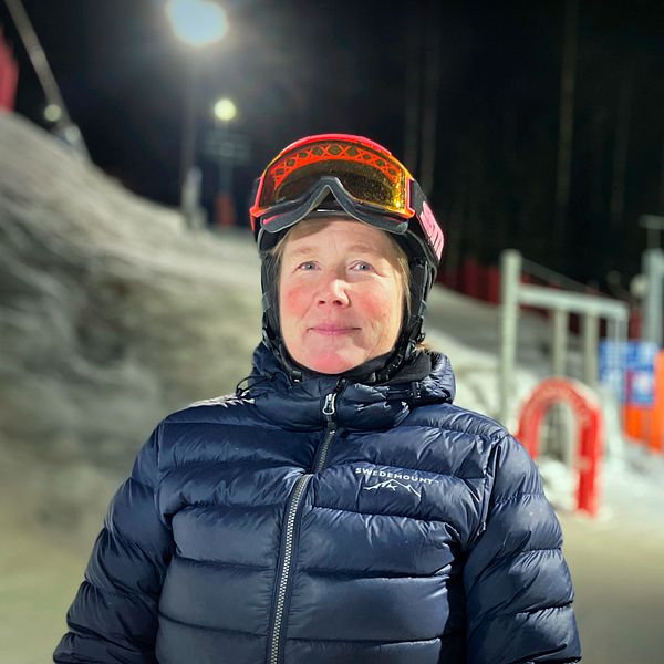 Helena Eriksson, ordförande för slalomklubben i Almåsa står med skidhjälm framför en lift.