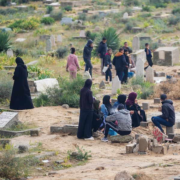 Människor sörjer sina döda närstående på en gravplats i Gaza.