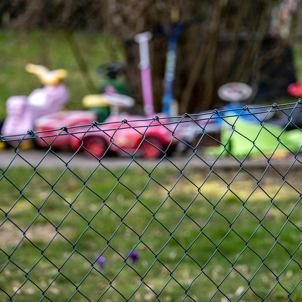 Leksaker på en trädgård bakom ett staket.