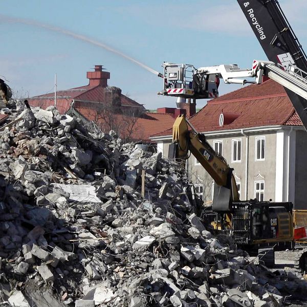 Flera maskiner och fordon river ned ett hus i Kirunas gamla centrum.