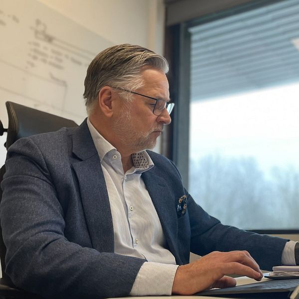 Christian Alexandersson tf kommundirektören i Bjuv sitter framför en dator i kommunhuset.