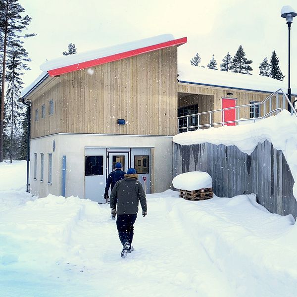 Person går mot det nya vattenkraftverket i Ejforsen, omgivet av snö och vinterlandskap.