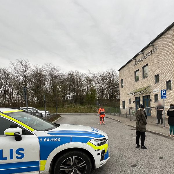 Personer och en polisbil framför Västervångskolan i Trelleborg.