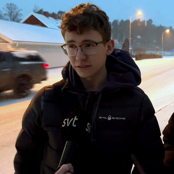 Två ungdomar vid en väg i snön