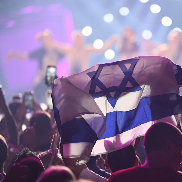 Israeliska flaggan i ett publikhav framför en scen