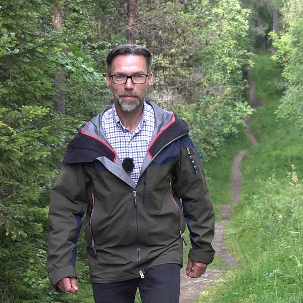 Andreas Edholm i en skog på i Östersund på en vandringsled går mot kameran