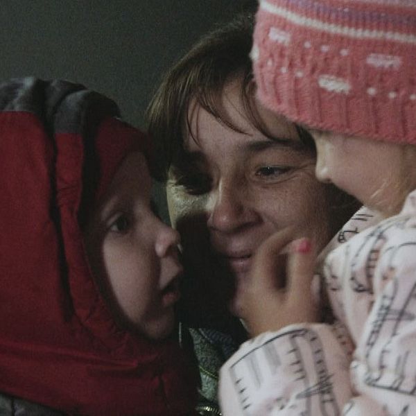 Viktor med röd luva återförenas med sin mamma och syster som ler