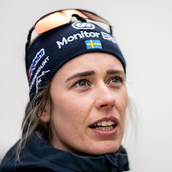 En person iförd en mössa med reklamlogotyper från sponsorer och ett par sportglasögon placerade ovanpå mössan.