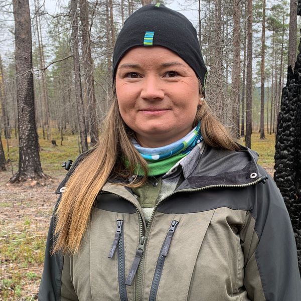 Therese Timber, natur- och miljövårdsspecialist på Sveaskog, står i ett naturreservat med brända tallar