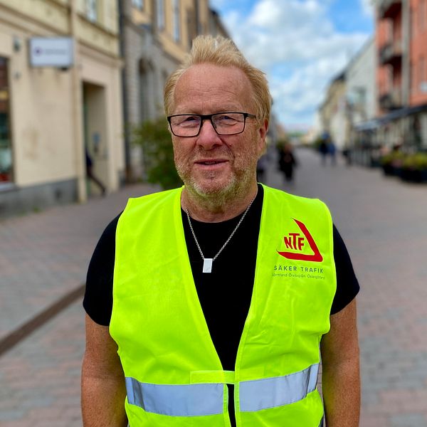 man med reflexväst på gågata