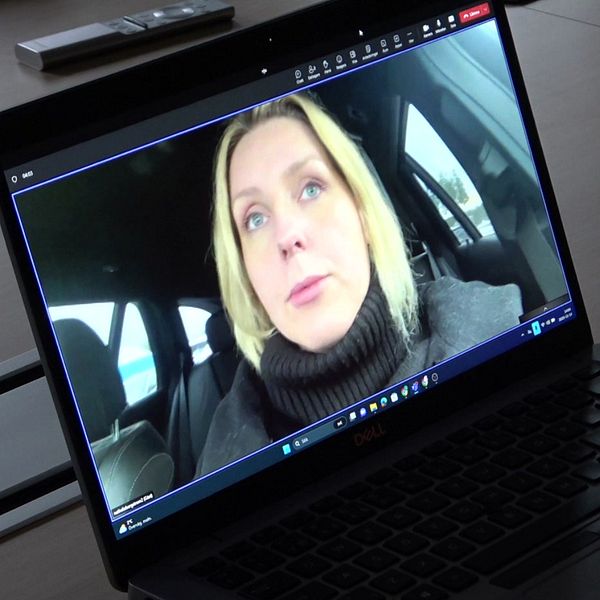 Dator som står på ett skrivbord. På skärmen syns en blond kvinna som sitter i en bil.