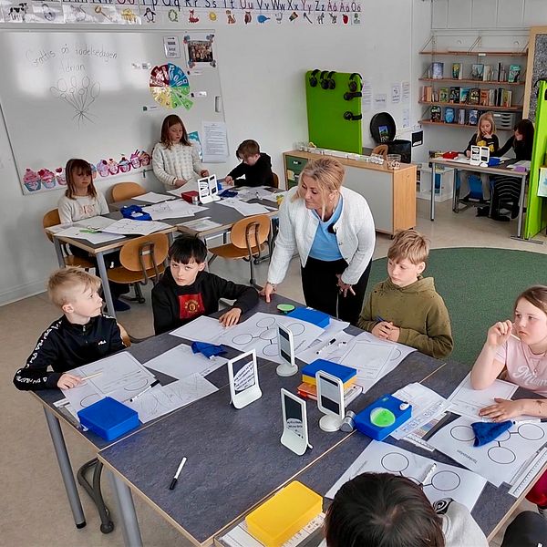 Elever och lärare arbetar engagerat i ett modernt klassrum.