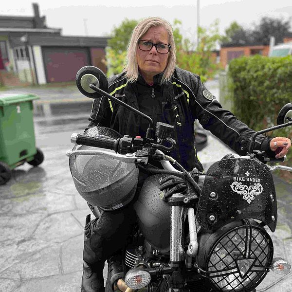 Kvinna sitter på motorcykel