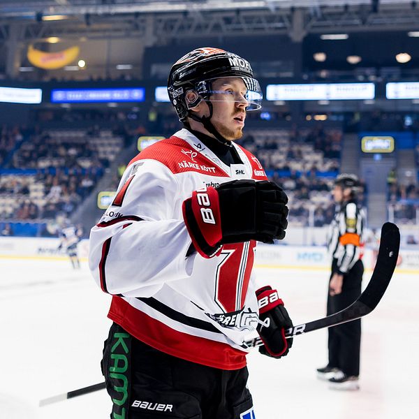 Ishockeyspelare går av isen under en match, publik syns i bakgrunden.