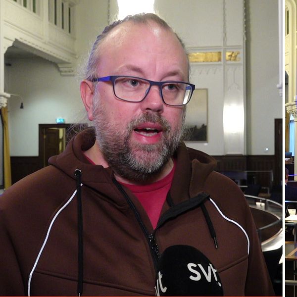 Till vänster står Mikael Enmalm, förälder. Han är klädd i en brun hoodie och står i salen där beslutet om nedläggningen togs. Till höger syns stora skärmar ovanför politikerna som sitter på sina platser.