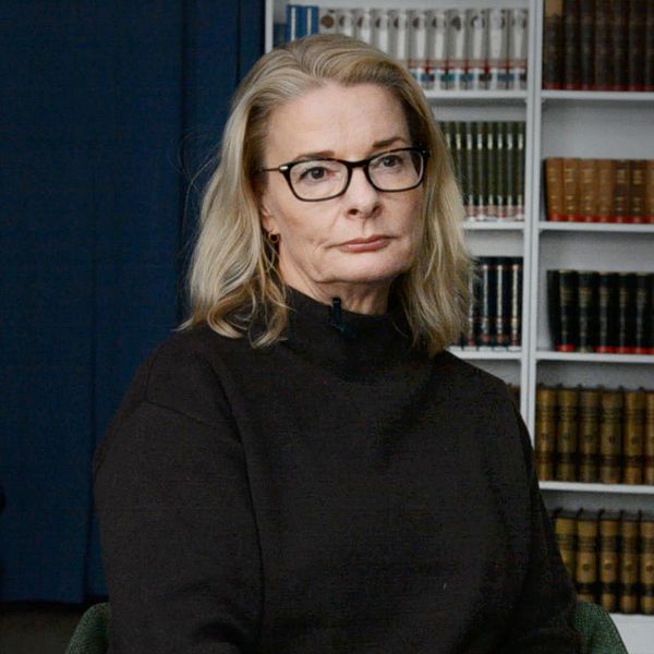Skolminister Lotta Edholm (L) sitter framför en bokhylla