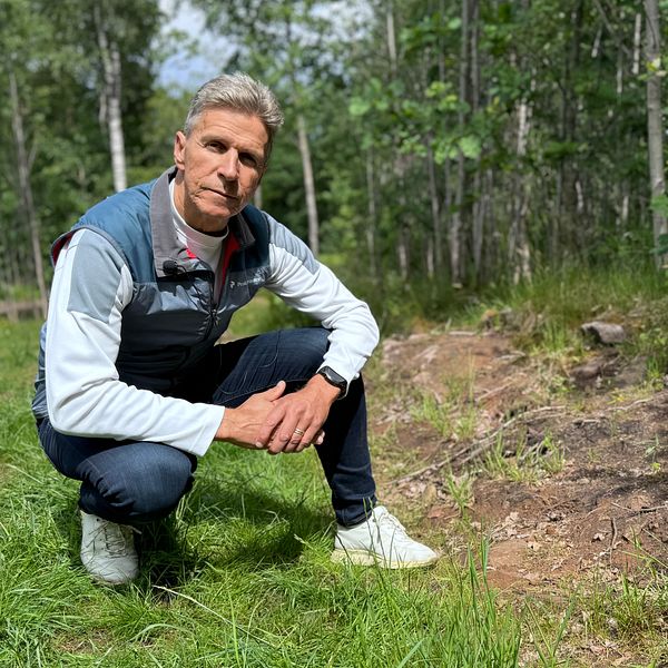 Johan Arvidsson sitter vid en skadad fornlämning.