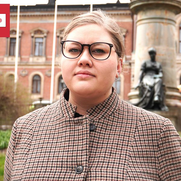 En kvinna från ett kårparti i Uppsala står utanför universitetet.