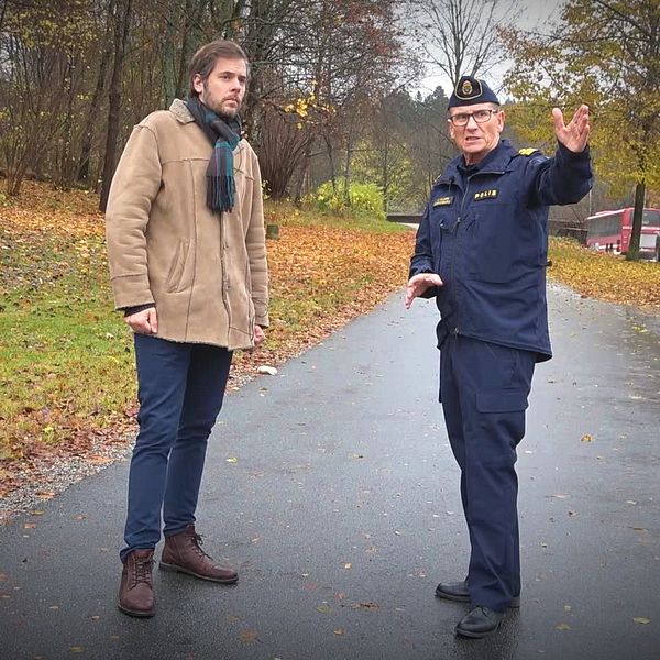 Reporter David Nilsson Hamne och polis står vid väg och polisen pekar mot kameran