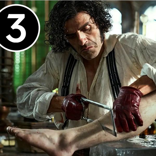 Oscar Isaac som Victor Frankenstein sågar i en död kropp i ett laboratorium i Guillermo Del Toros ”Frankenstein”