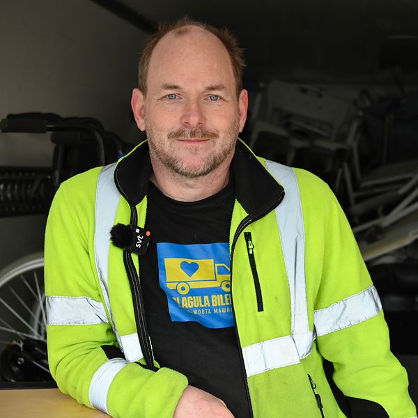 Grundaren till Blågula Bilen lutar sig mot ett bord