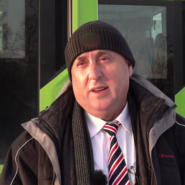Busschauffören Hisni Rinasi står framför en buss i Eskilstuna.