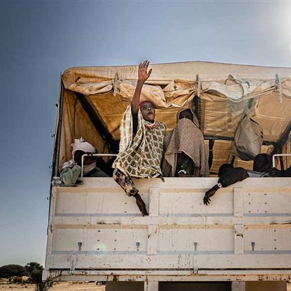 Sudanesiska flyktingar sitter i en lastbil i ett tillfälligt insamlingsläger i Tchad.