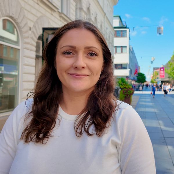 En kvinna, klädd i vitt, på en gågata i Eskilstuna
