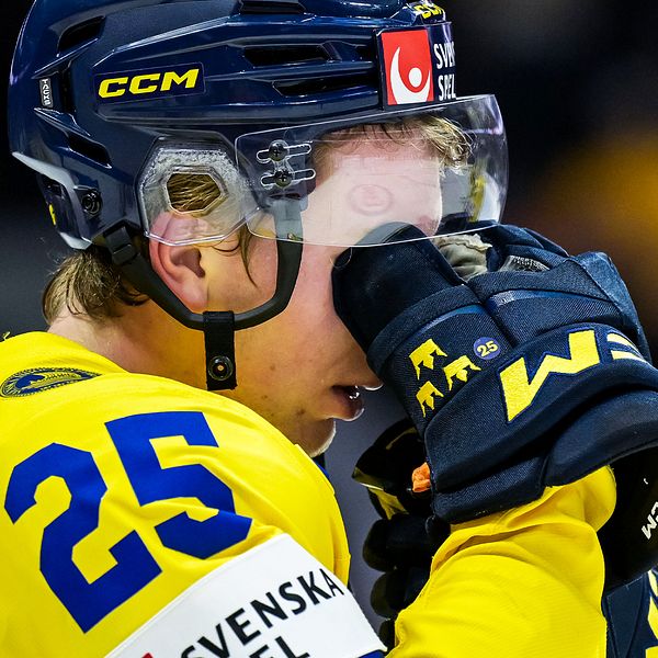 En delad bild som visar två sektioner av en svensk ishockeyspelare i en gul matchtröja. Den vänstra sektionen visar spelaren som kramar en lagkamrat, med tydlig fokus på nummer 25 på tröjan. Den högra sektionen visar samma spelare som håller sin klubba, i en uppmuntrande pose. Kontexten tyder på en känslosam stund under en match eller ett firande.