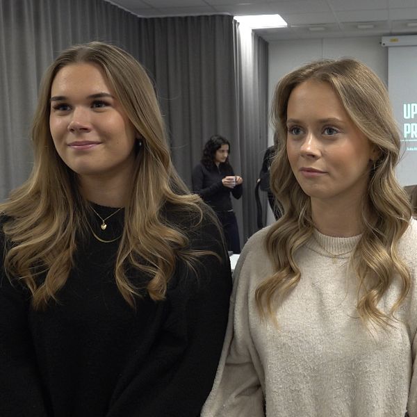 Ella Lööf och Elsa Svensson står i en klassrumsmiljö med deltagare och en presentation på skärmen.