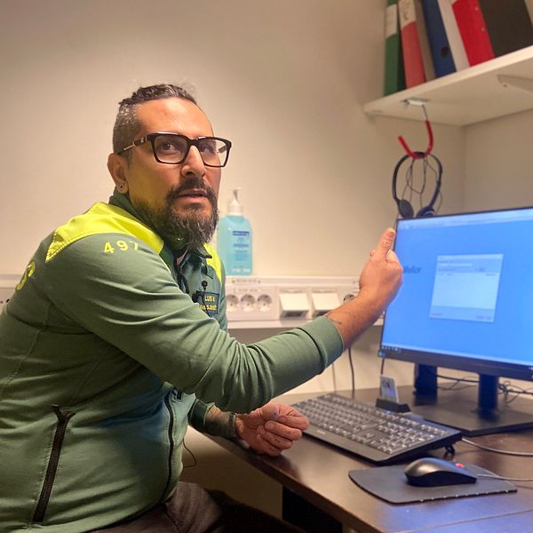 Ambulanssjuksköterskan Luis Monroy sitter framför en dataskärm inne på ambulansen.