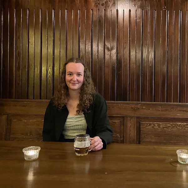Kvinnliga ölkännaren Amanda Knöös sitter i en bar och dricker en ljus lager.