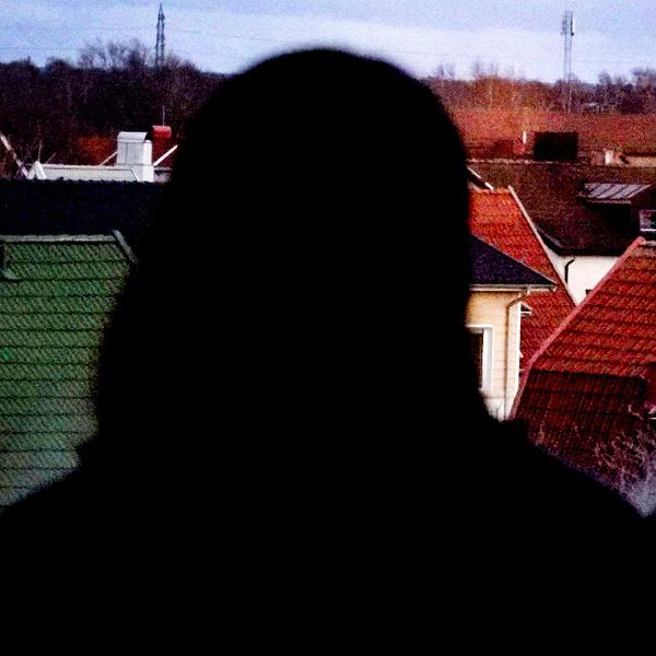 Anonym person framför ett fönster.