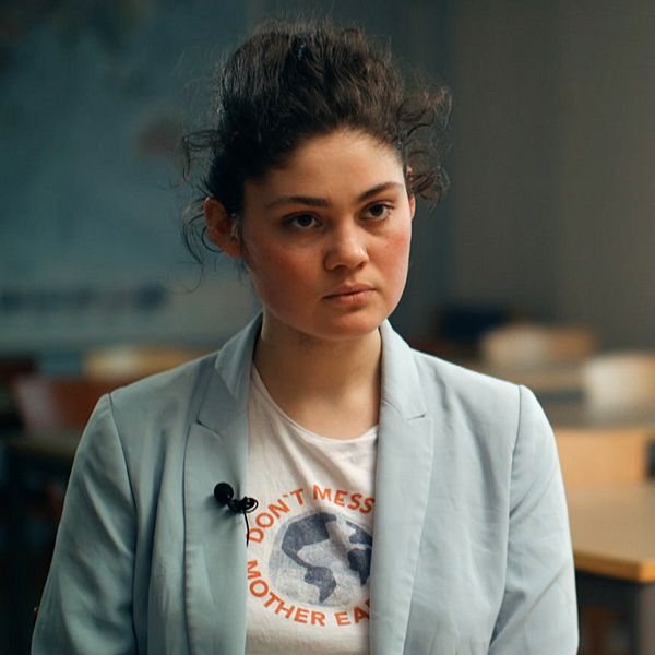 Ida Edling, talesperson för klimaträttviserörelsen Aurora, ung kvinna i ljusblå kavaj och uppsatt mörkt hår intervjuas i ett klassrum