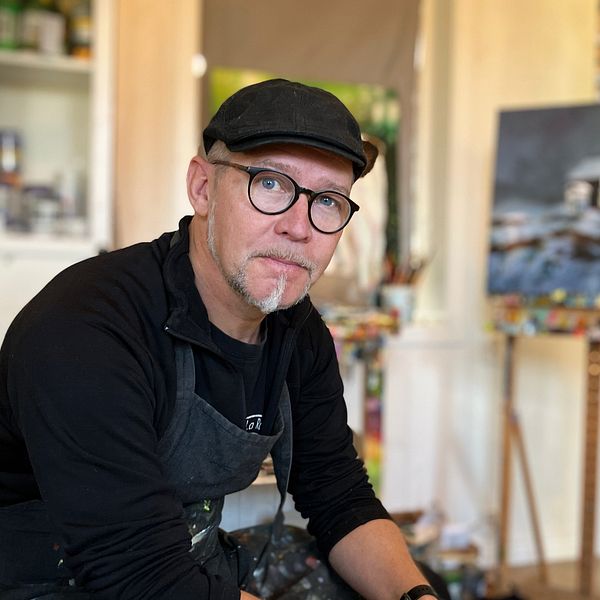 En man, Mathias Kärnlund, konstnär, sitter i sin studio utanför Östersund.