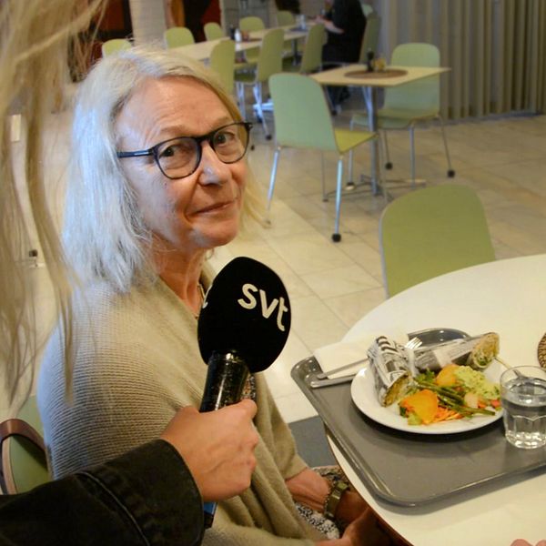 En kvinna sitter på stadhusets restaurang i Södertälje och äter en beredskapsrulle