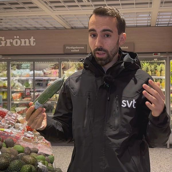 SVT:s reporter Alberto Lozano står i en matbutik med en plastinslagen gurka i handen