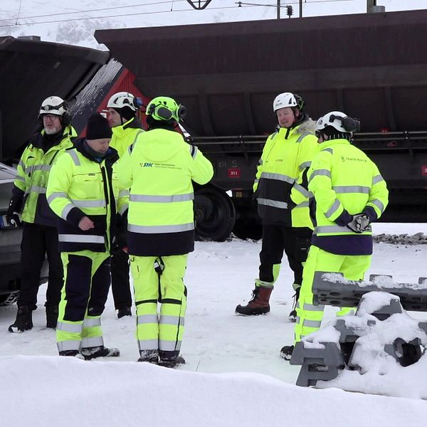 Anställda från Statens haverikommission och Trafikverket framför ett malmtåg vid olycksplatsen.