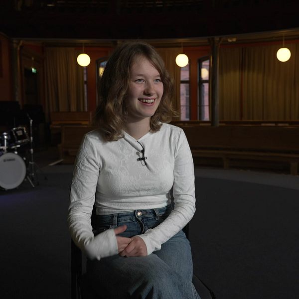Anna Palmblom sitter i en sal och berättar om sitt skrivande och tävlingen.