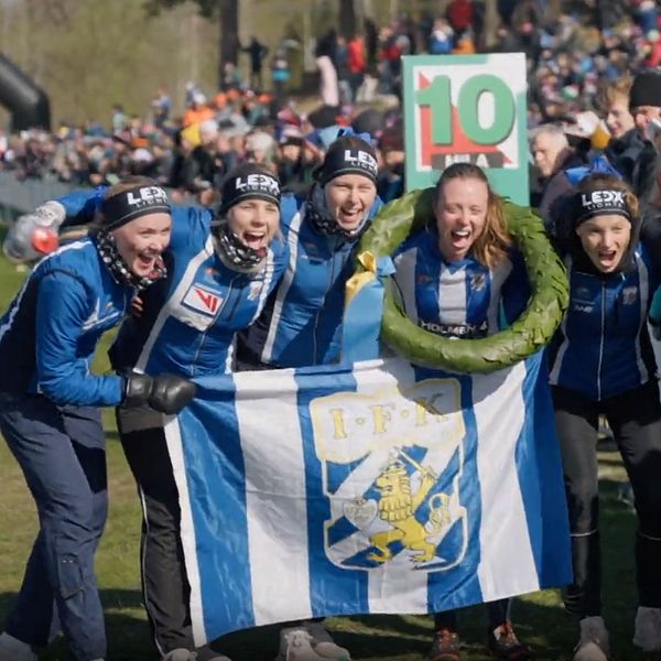 Sex glada löpare jublar med IFK Göteborgs fana och segerkrans efter målgång.