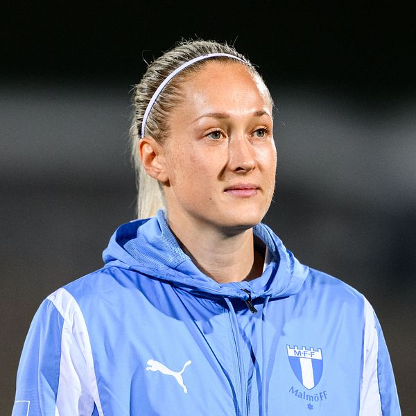 En person iklädd Malmö FF:s blå träningsjacka med en Puma-logga på bröstet.