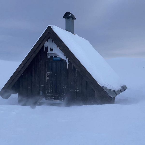 en liten raststuga på fjället, mycket snö och blåst