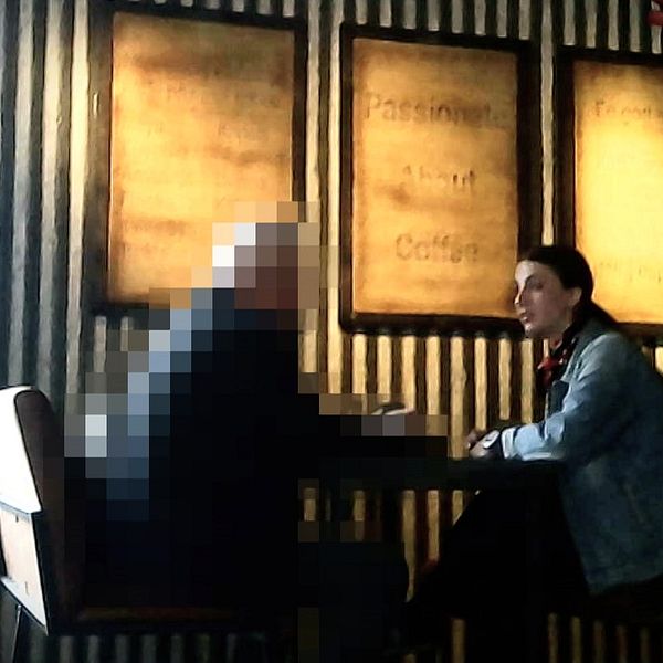 En pixlad man sitter på café med en kvinna