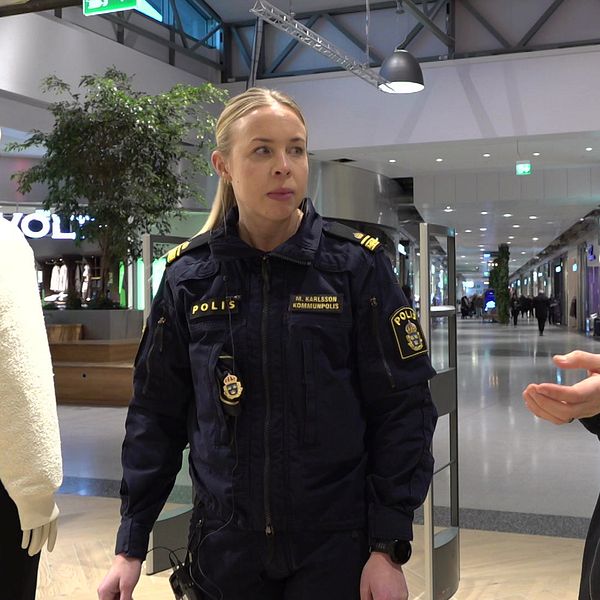 En reporter intervjuar en polis i en klädbutik