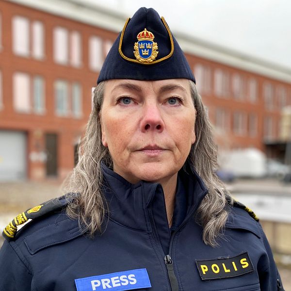 kvinna i polisuniform med presslogga