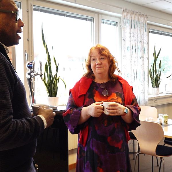 Forskaren Lina Lid Falkman vid Karlstads universitet står i fikarummet med en kaffekopp i handen och pratar med sina kollegor.