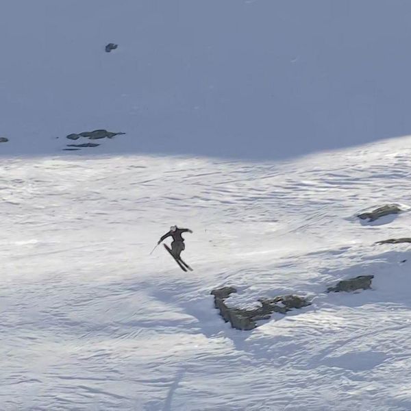 En tävlande i extremskidåkning i Riksgränsen hoppar i backen.