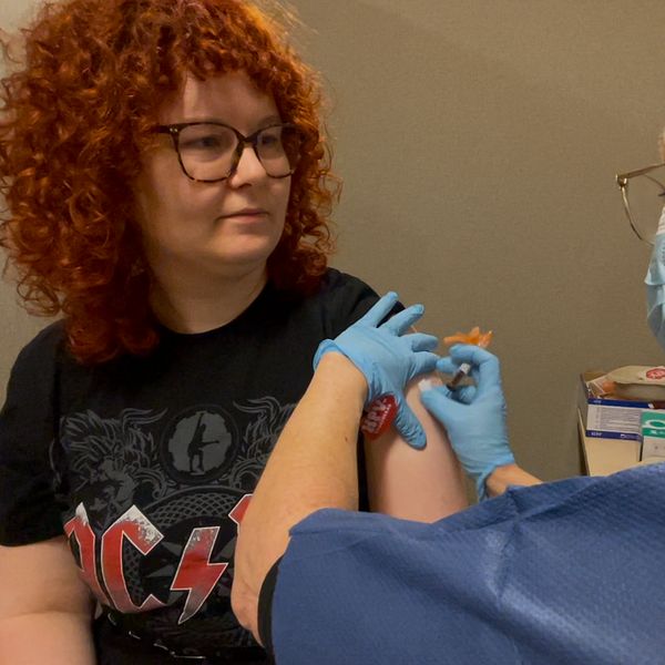 En kvinna får en spruta med HPV-vaccin av en sjuksköterska